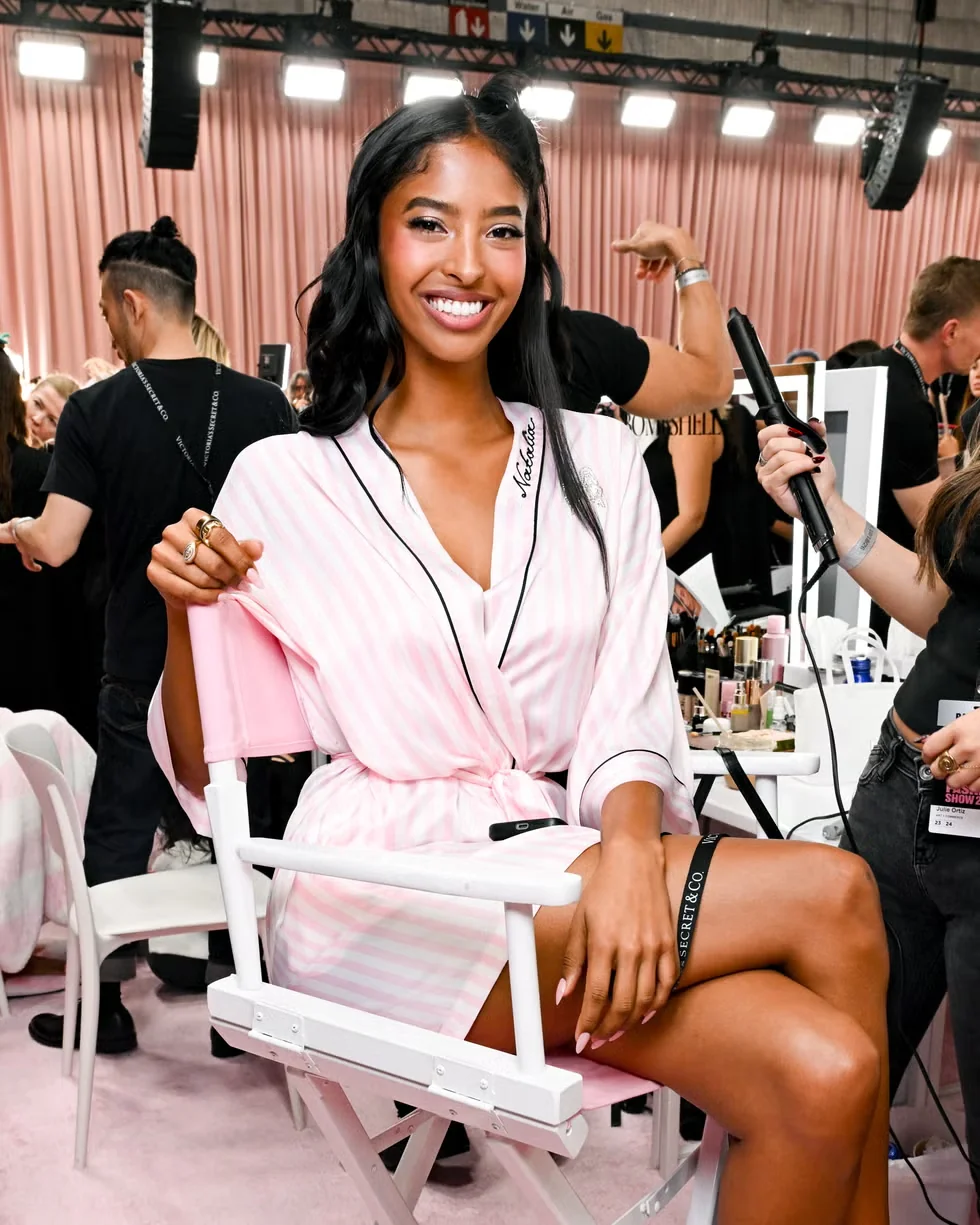 Backstage makeup and hair preparation in a pink striped robe